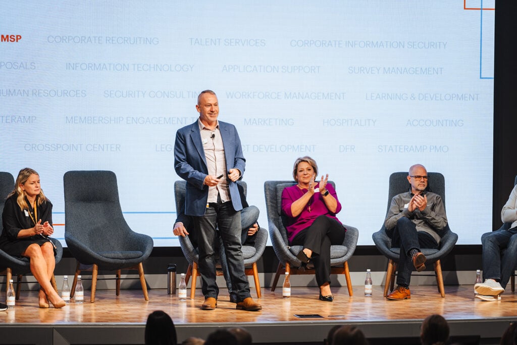 Photograph of Knowledge Services Day of ThanKS 2023, with Senior Vice President Bill Evans highlighting achievements in Survey Management, Workforce Management, and Managed Service Provider offerings.