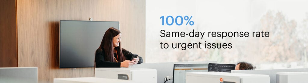 Photo of employees in office with text: "100% same-day response rate to urgent issues."