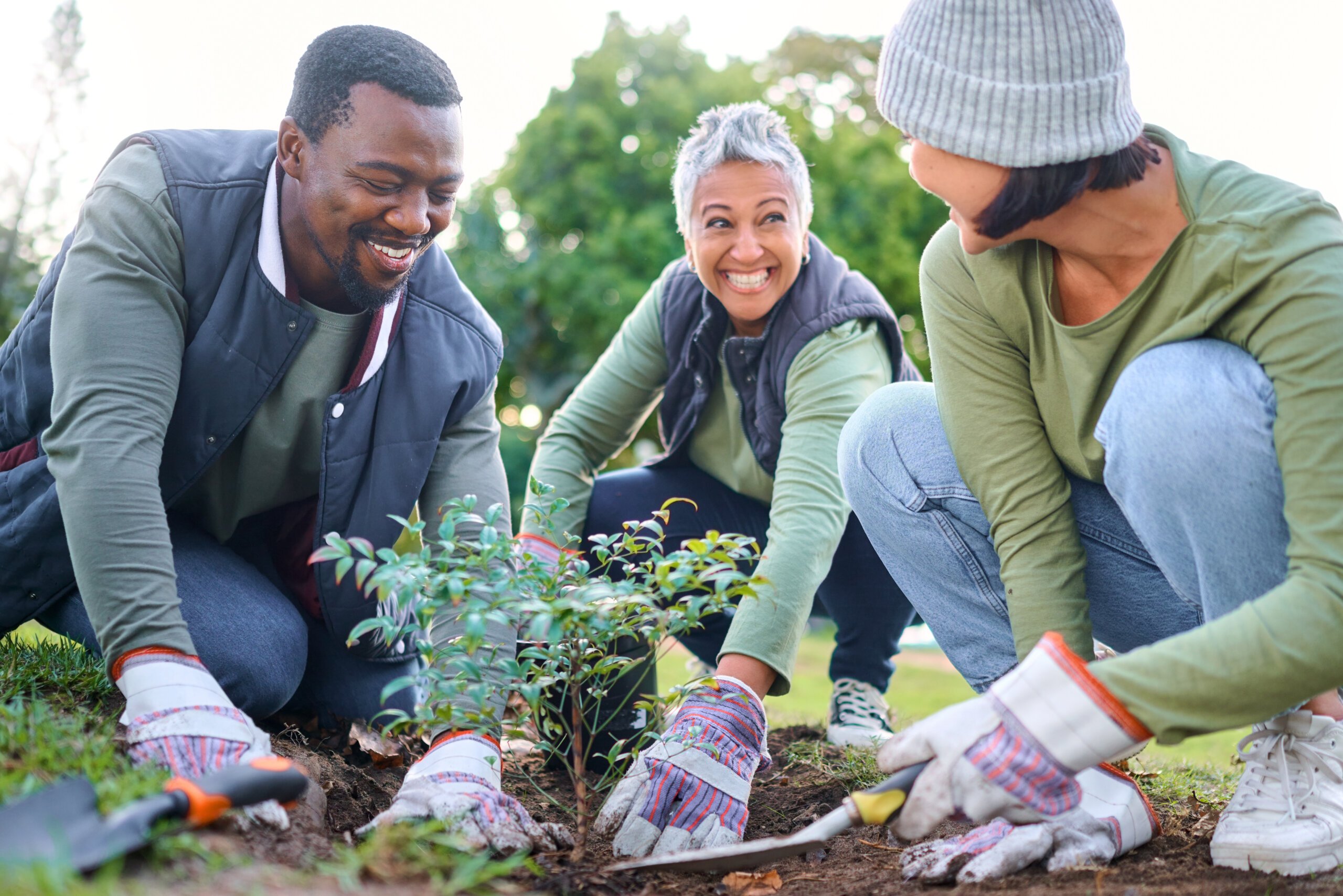 A group of smiling people working in a garden.