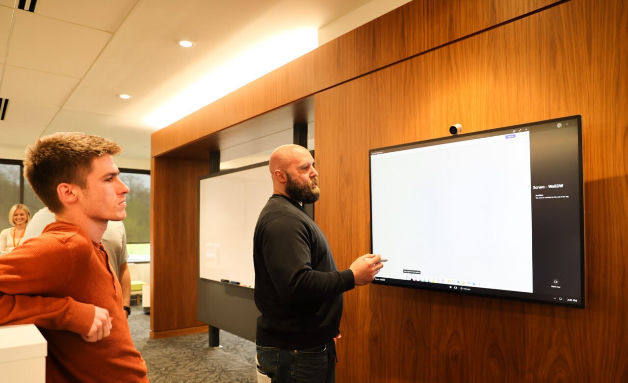 Image of two men writing on whiteboard