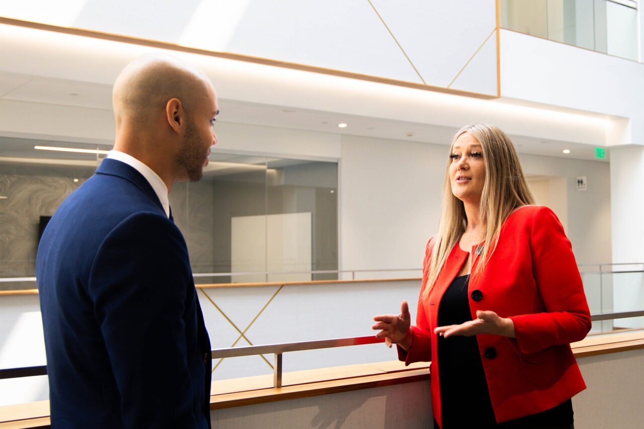 Image of two colleagues talking in atrium