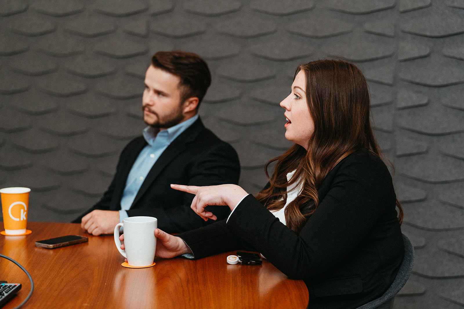 Image of woman lecturing a group of people at a conference table