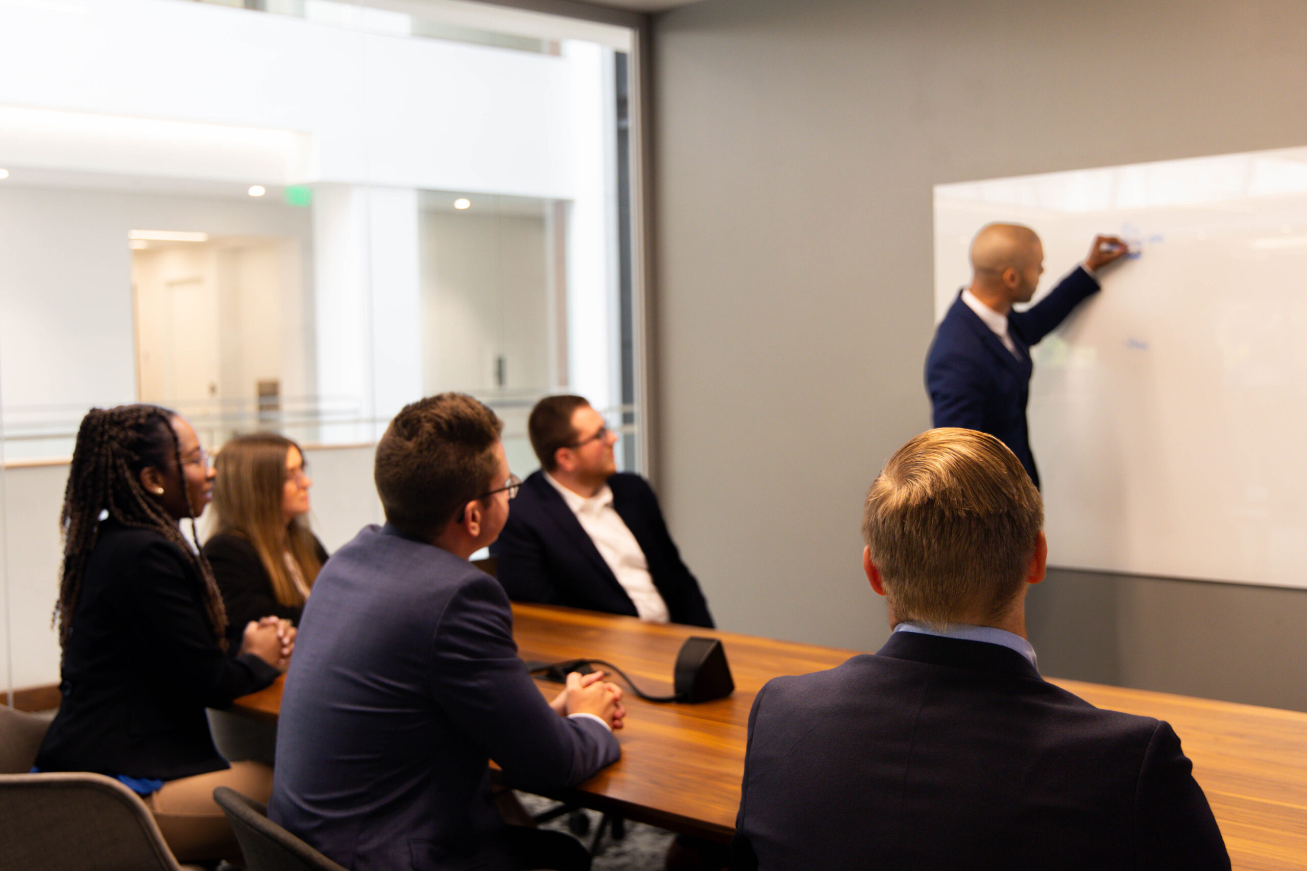 Image of woman lecturing a group of people at a conference table